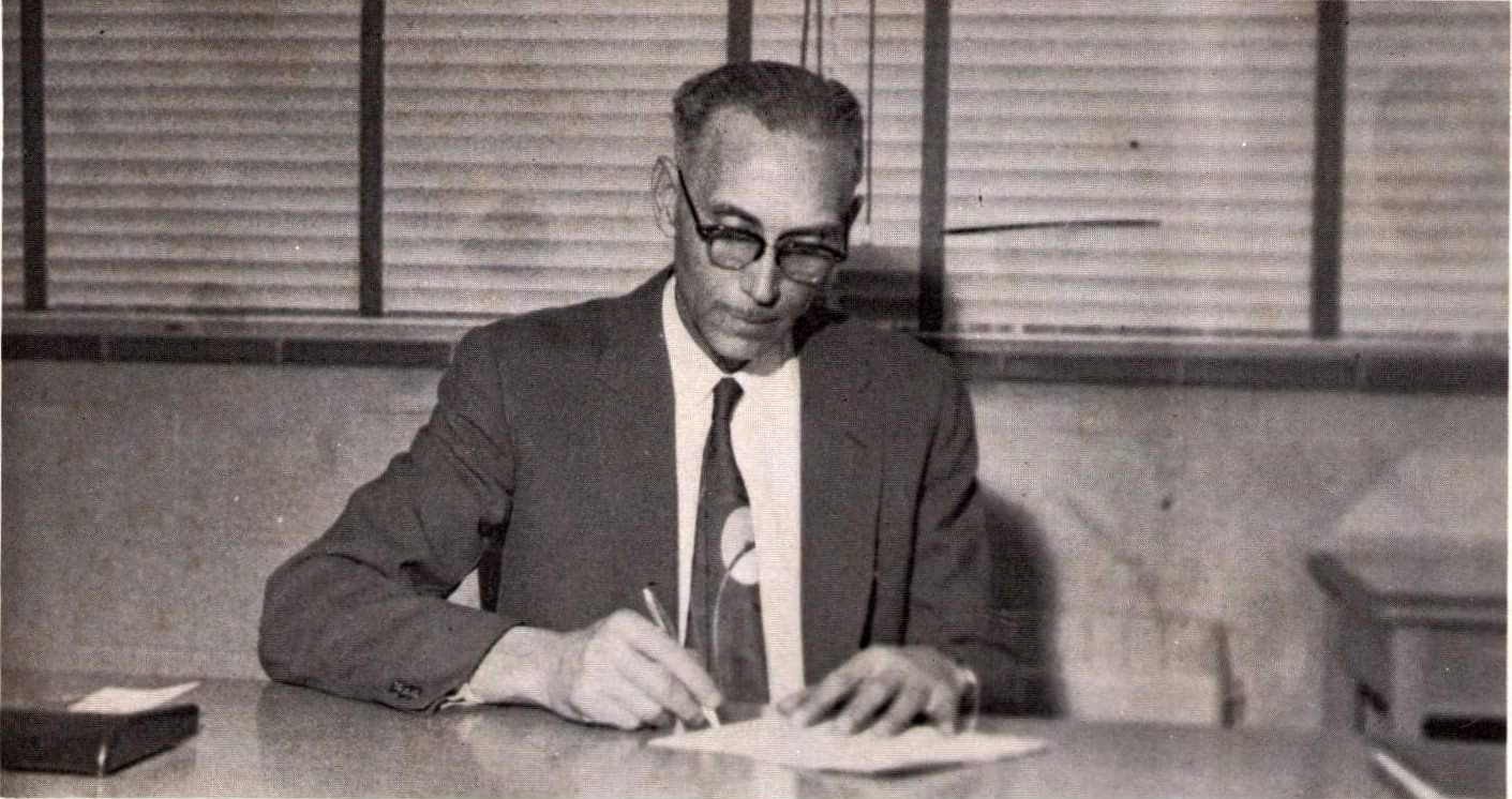 Photograph of Sandford Bradby writing while sitting at a desk.